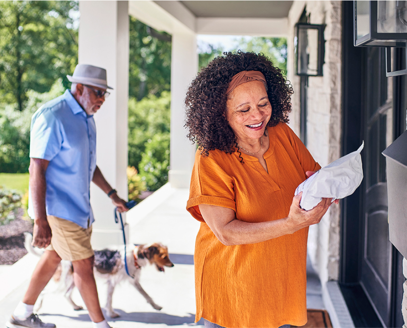 A prescriber receives their medication in the mail while a family member walks the dog.