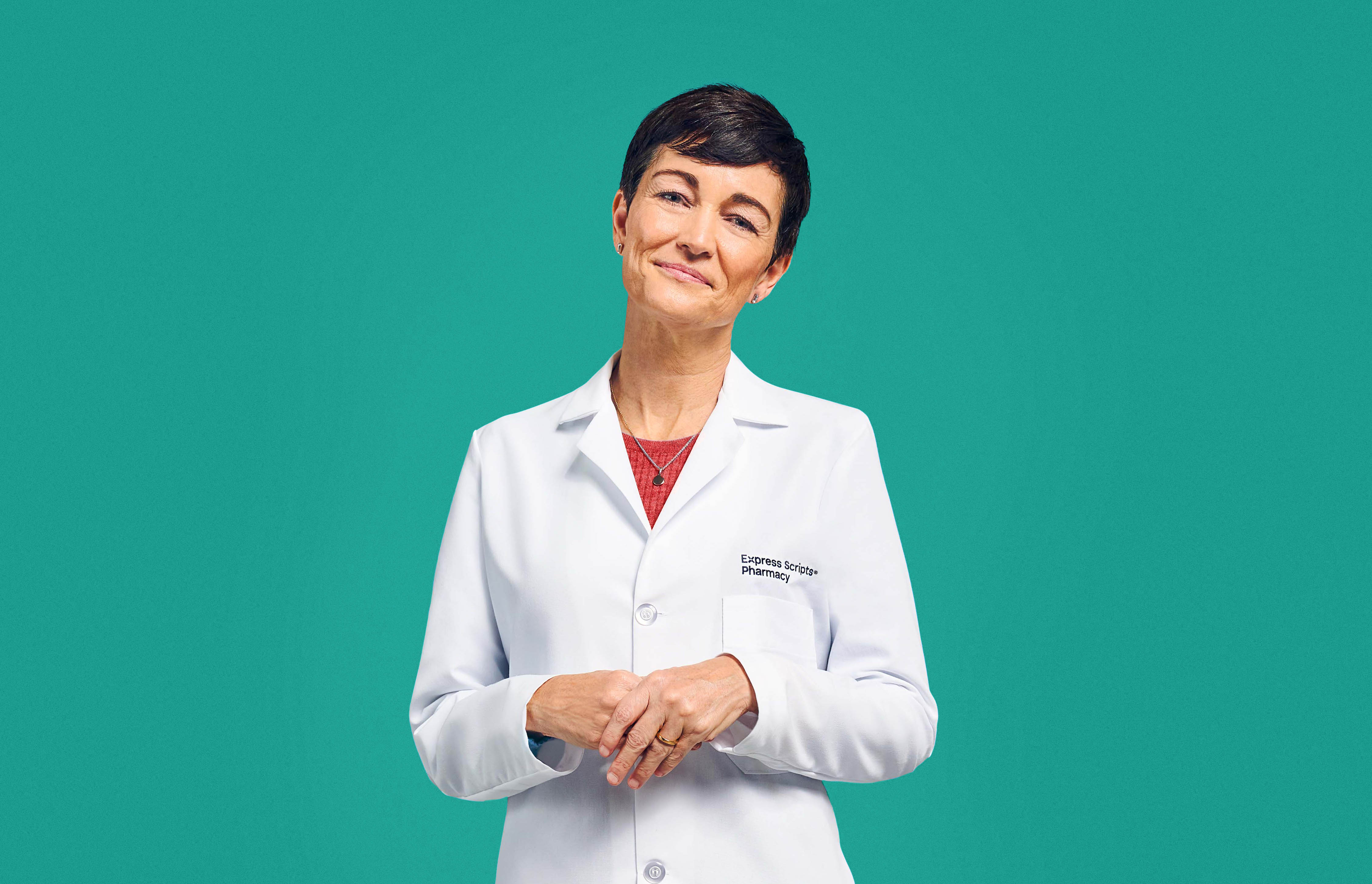 A pharmacist smiles in her Express Scripts® Pharmacy lab coat.