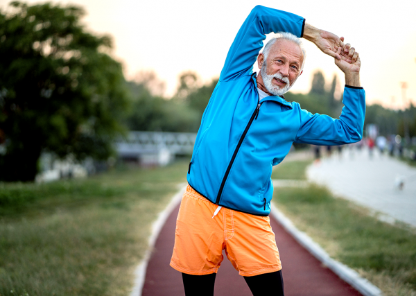 Older man stretching outdoors.