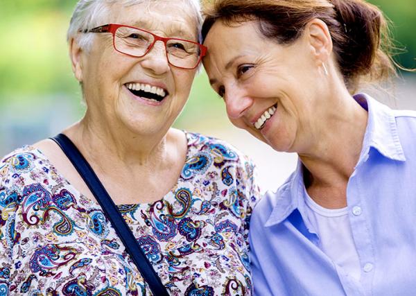 A woman and her elderly mother enjoy time outside together.