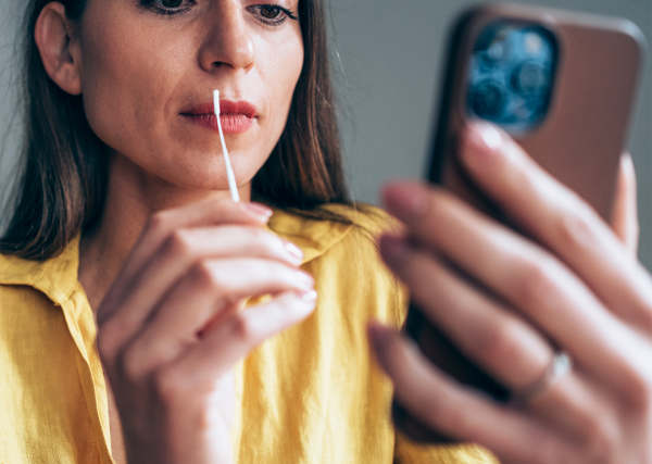 A woman swabs her nostril as part of her at-home COVID-19 test.