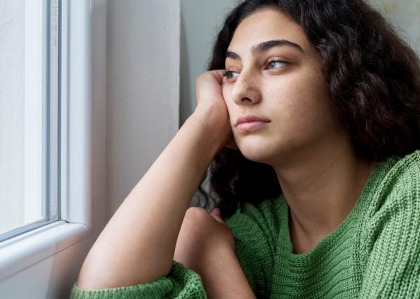 A young woman gazes out a window 