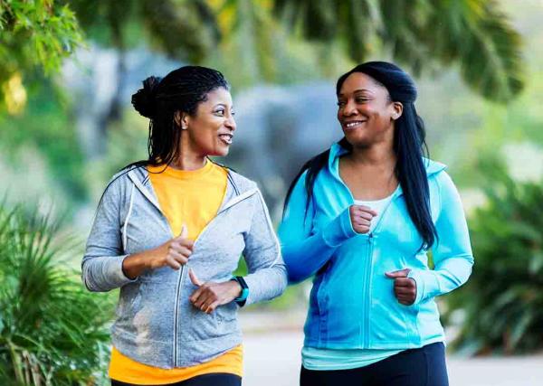 Two women enjoy a walk outside while they talk.