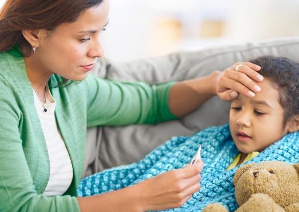 A woman comforts her ill child while while she rests