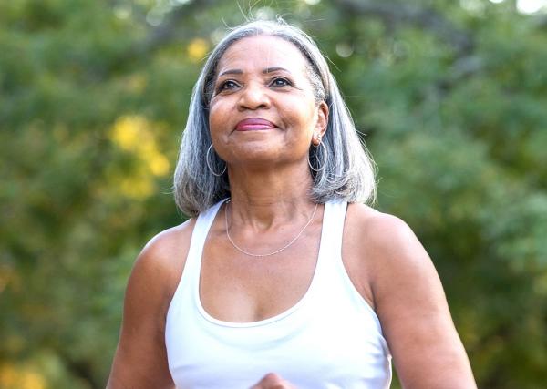 An older woman enjoys a jog outside.