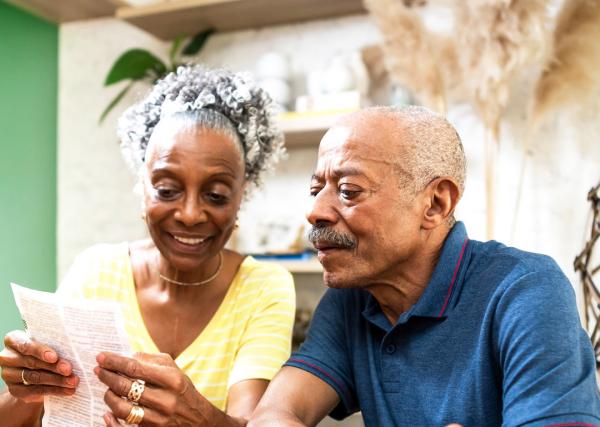 An older couple looks over the information that came with one of their prescription medications.