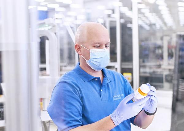 A pharmacy technician at Express Scripts® Pharmacy checks a prescription bottle label.