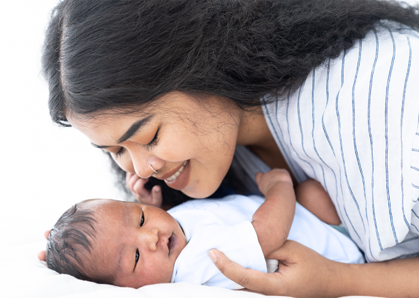 A new mother sweetly cuddles with her newborn baby.