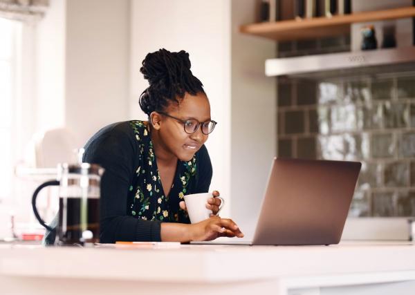 A young woman does research on her prescription medication using her laptop computer.