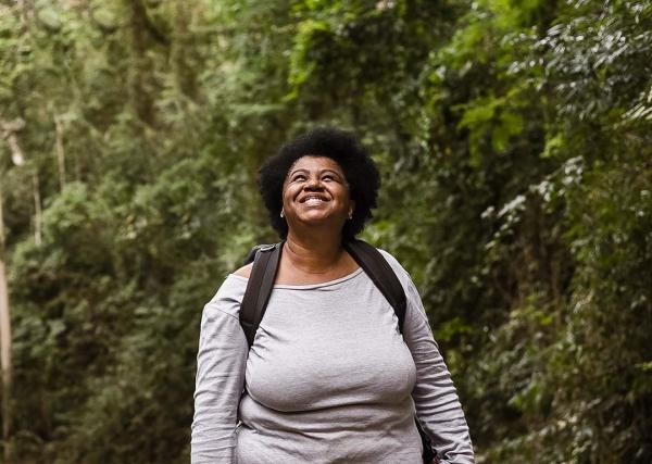 A woman enjoys a walk outdoors on a walking path.