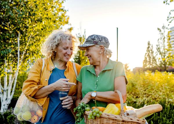 Two older women walking and laughing.