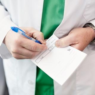 A doctor writes a prescription for a patient.