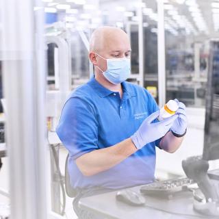 A pharmacy technician at Express Scripts® Pharmacy checks a prescription bottle label.