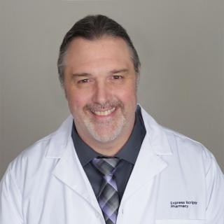 Bill Smith, a registered pharmacist with Express Scripts® Pharmacy, smiles in his white lab coat.